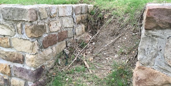 A yard showing signs of soil erosion due to drainage issues